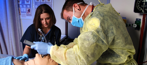Two students operating on a manikin
