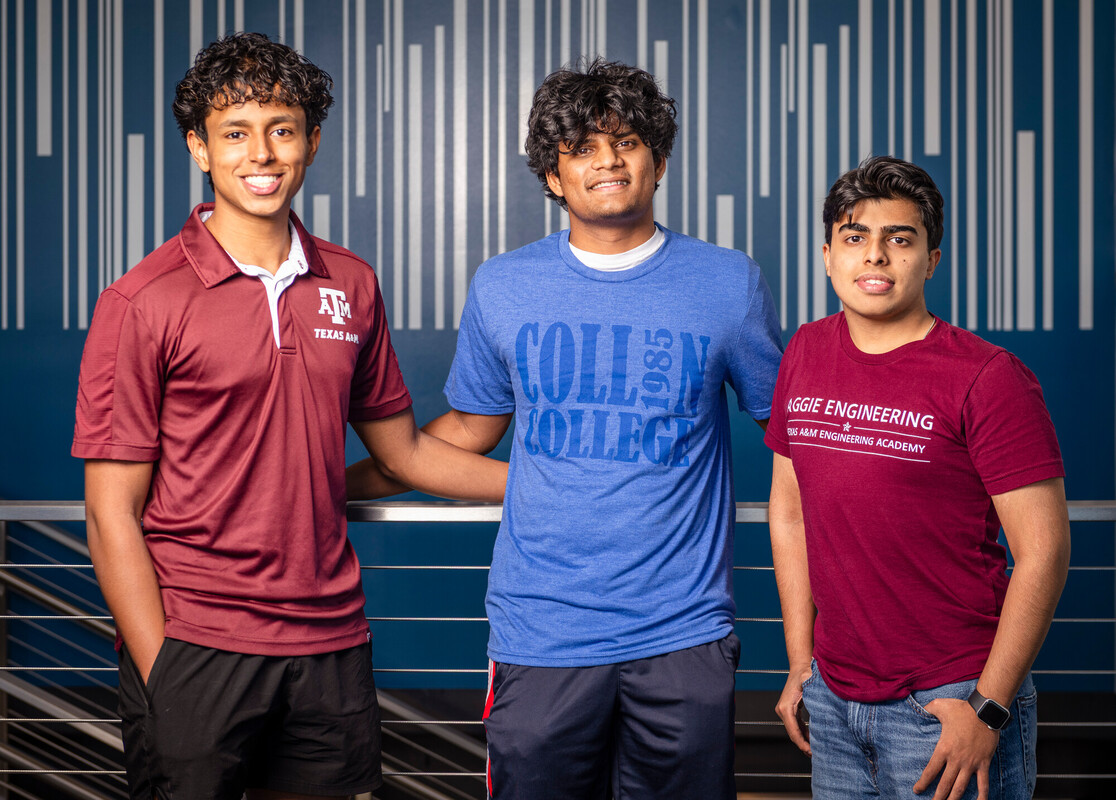 three young men in front of blue wall
