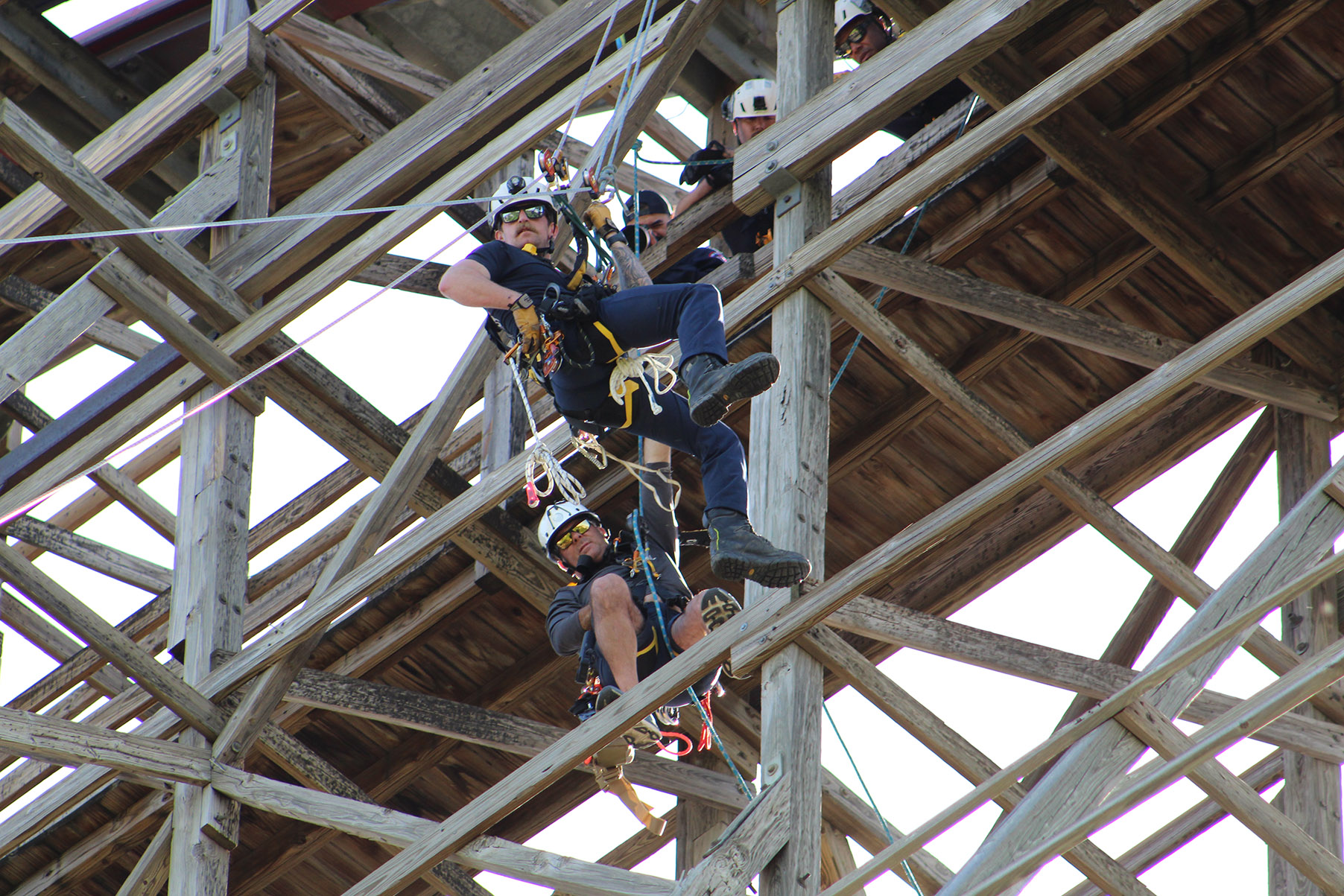Arlington firefighters stand with Collin College Fire Science Instructor Brian Luyster in front of a Six Flags rollercoaster during a three-day training event.