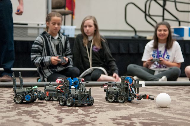 Picture of summer camp participants using remote-controlled robotics.