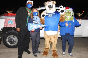 金沙博彩参加了法默斯维尔的年度圣诞游行, staff posing with Collin Cougar mascot.