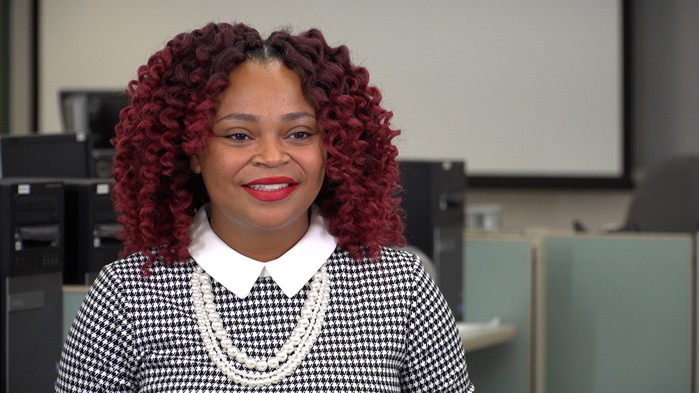 Picture of Christin Jones smiling as she talks about her experience in the Cybersecurity program.