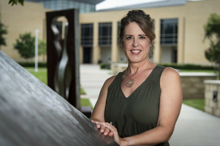 Photo of Shari Eberhard smiling at the camera outside of the Frisco Campus.