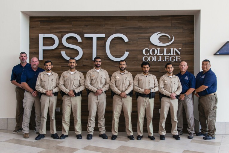 Cadets from the UAE stand with Collin College Law Enforcement Academy leaders in front of the Public Safety Training Center.