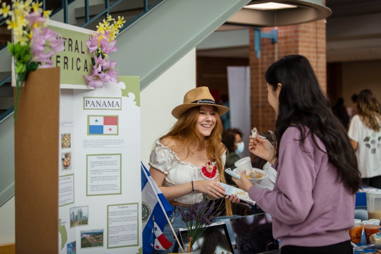 ESL student discusses a display about Central America with another Collin student at the Multicultral Festival.