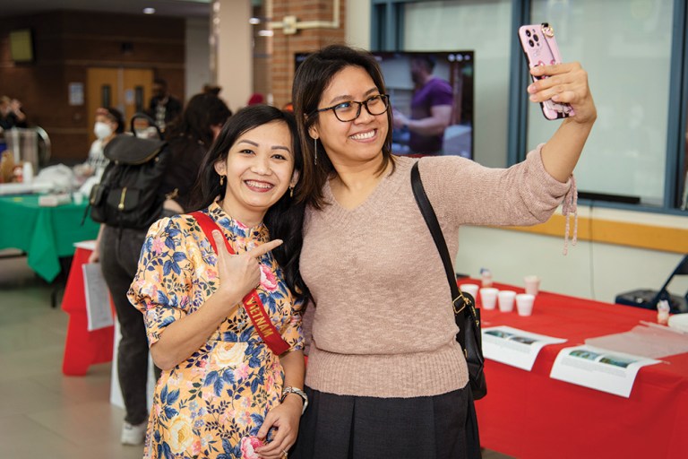Students take selfies during an event at Collin College